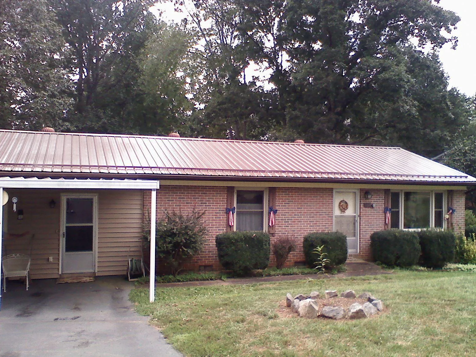Bronze metal roof and carport on a brick ranch home — Roof Repair work by our crew in Zebulon