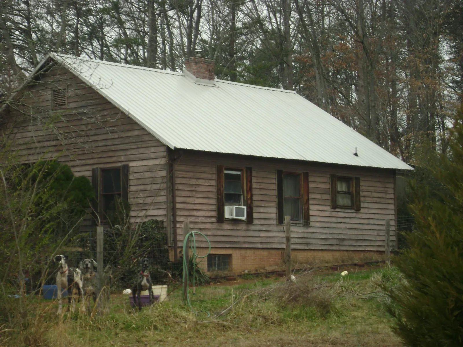 White metal roof on an old wood sided farmhouse, from a Metal Roof Installation job in Zebulon